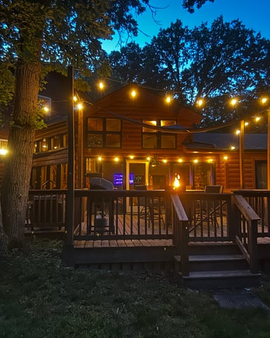 Deck at dusk with fire pit, hot tub, and string lights