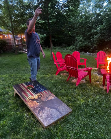 Evening deck with fire pit, hot tub, and string lights